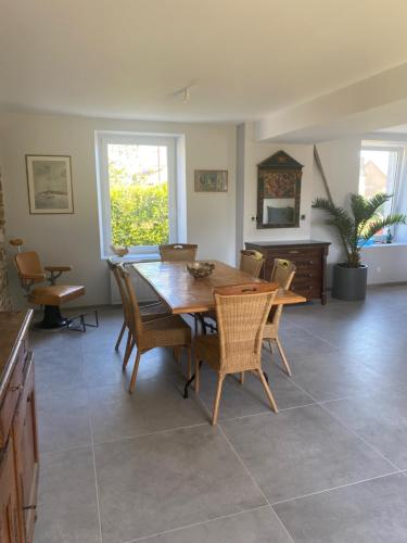 une salle à manger avec une table et des chaises en bois dans l'établissement La Maison du Pays Coutançais, à Gouville-sur-Mer