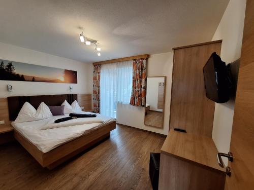 um quarto de hotel com uma cama e uma televisão em Die Schladmingerin em Schladming