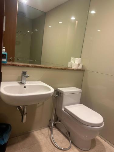 Soho Suites KLCC By Inam Suites في كوالالمبور: حمام مع حوض ومرحاض ومرآة