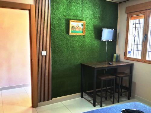 una camera con una parete verde, una scrivania e una finestra di Nueva habitación con llaves baño privado a Granada