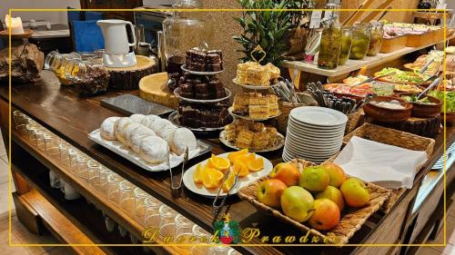 a buffet of food with fruit and bread and desserts at Dworek Prawdzic Niechorze in Niechorze