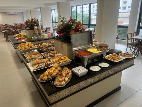 una línea de buffet con muchos tipos diferentes de comida en Hotel das Américas en Balneário Camboriú