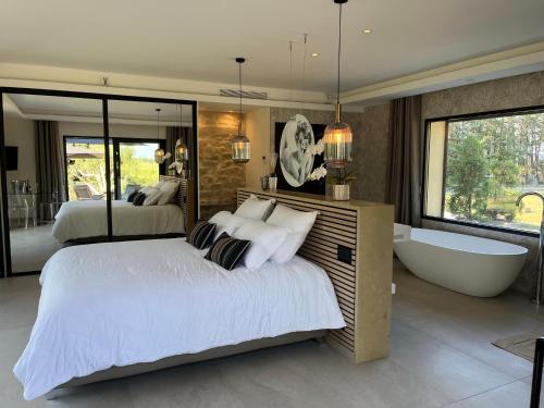 ein Schlafzimmer mit einem großen Bett und einer Badewanne in der Unterkunft Domaine de La Franquette by Bridget & Pascal in Caderousse
