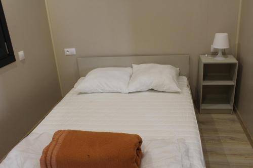 a bed with two pillows and an orange towel on it at le clos du popey in Saint-Romain-de-Popey