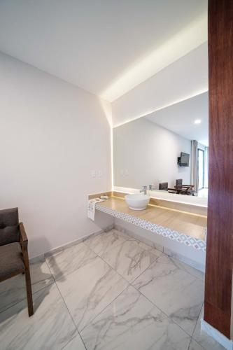 a white bathroom with a sink and a tub at Luna Azul Bacalar in Bacalar