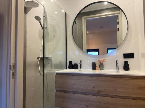 W łazience znajduje się prysznic, lustro i umywalka. w obiekcie B&B Kuiper in Friesland w mieście Ureterp