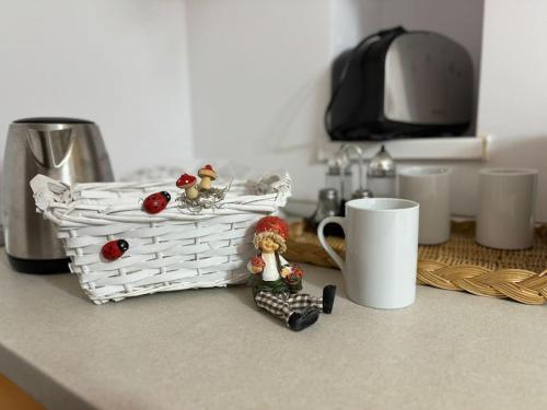 a kitchen counter with a basket and figurines on it at IaZi Apartament in Braşov