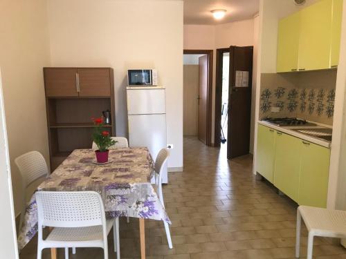 a kitchen with a table with chairs and a refrigerator at Le Villette di Villa Paola in Loano