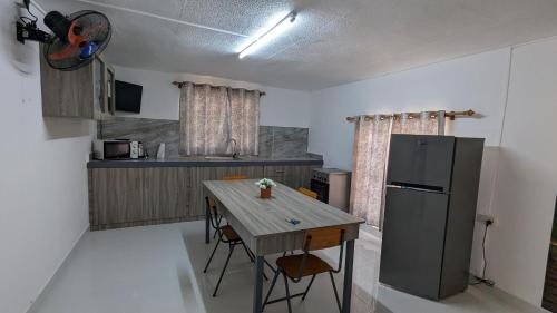 a kitchen with a wooden table and a refrigerator at An&Sy Family House in Surinam