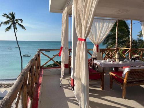Cassandra Beach Resort في نونغوي: شرفة مع طاولة وكراسي على الشاطئ