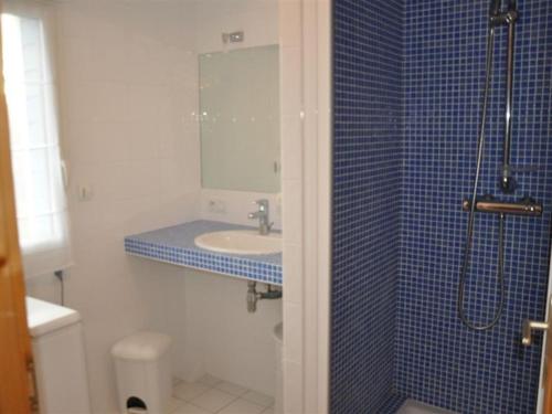 La salle de bains est pourvue d'un lavabo et d'une douche carrelée en bleu. dans l'établissement Maison moderne à 100m de la plage à Trégastel - FR-1-368-203, à Trégastel