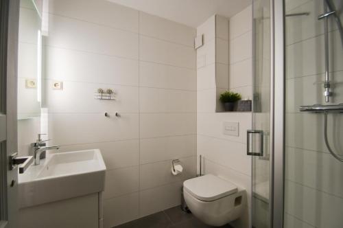 オストゼーバート・ゼリンにあるFerienappartement mit Seeblick und Balkonの白いバスルーム(トイレ、シンク付)