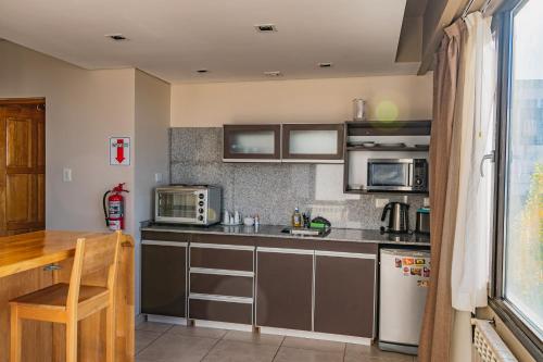 a kitchen with stainless steel appliances and a table at Miralejos in Ushuaia