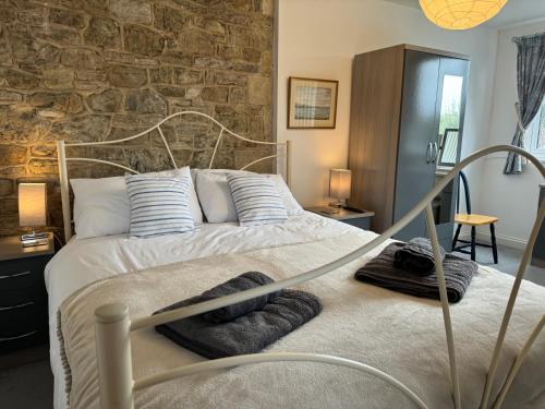 een slaapkamer met een bed met een stenen muur bij Mulberry Lawn Apartments in Brading