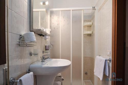 Baño blanco con lavabo y espejo en Al Bacino Rooms And Breakfast, en Porto Viro