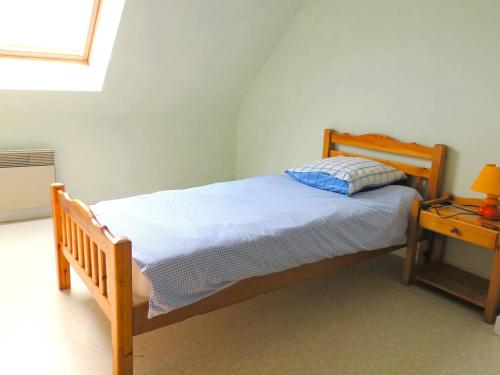 - une chambre avec un lit en bois et une table de chevet dans l'établissement Maison 3* avec jardin, wifi, à 400m de la plage à Pleumeur-Bodou - FR-1-368-286, à Pleumeur-Bodou