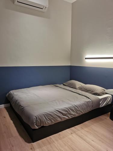 un letto in una camera con parete blu di Number Six Smart Guest House a Raub