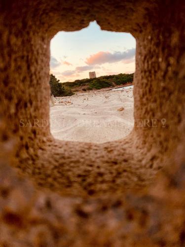 a view of the beach through a hole in the sand at Villetta Meraviglia a 100 m dalla spiaggia in Vignola Mare