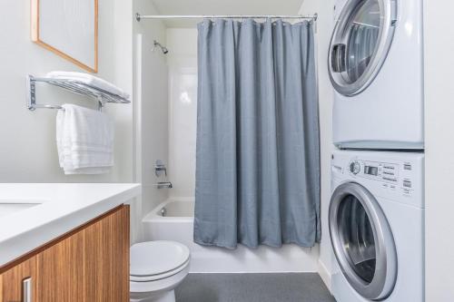 a bathroom with a washing machine and a washer at Seattle Modern and Stylish Penthouse Apartment (Wifi, Pet Friendly, Rooftop) in Seattle