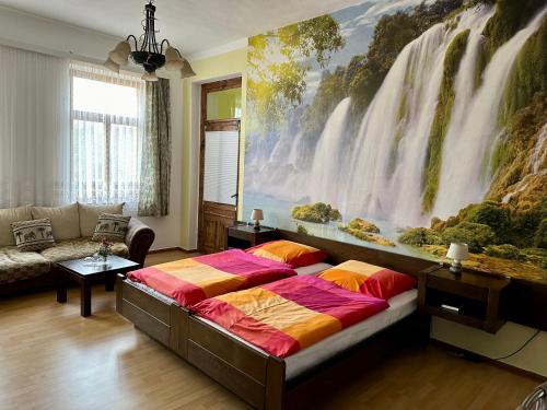 a bedroom with a large waterfall mural on the wall at Hotel Weinhaus Eberitzsch GmbH in Bad Blankenburg