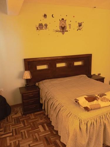 - une chambre avec un grand lit et une tête de lit en bois dans l'établissement Carnaval Oruro 2024 Habitación, à Oruro