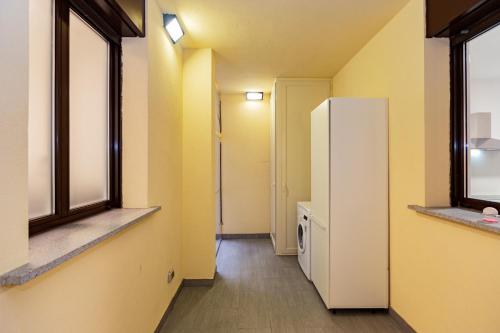 a hallway with a white refrigerator and two windows at PREMUDA20 Milan Elegant Apartment in Milan
