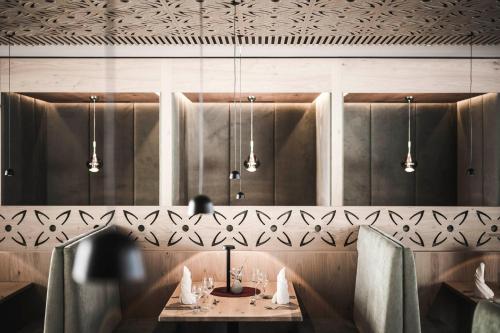 a dining room with a table and lights at Sporthotel Bachmann in Gargellen