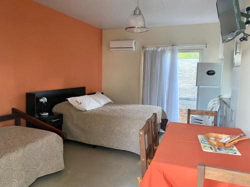 a room with two beds and a table and a window at Indalo in Termas del Daymán