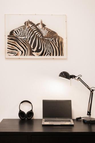 a desk with a laptop computer and a picture of zebras at Casa Imbarcadero in Lecco