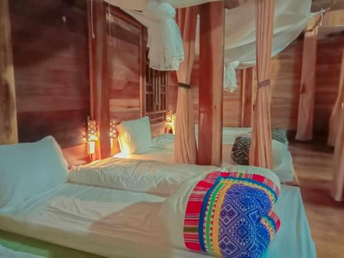 1 dormitorio con 2 camas con sábanas y almohadas blancas en Homestay Mạnh Châu, en An Pon