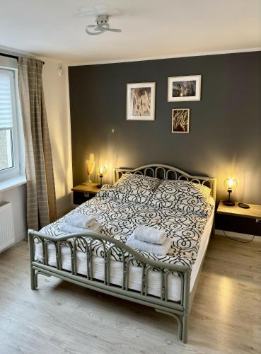 a bed in a bedroom with two tables and two lamps at Apartamenty Kowalska III in Kościerzyna