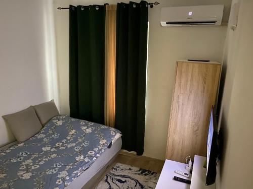 a bedroom with a bed and a desk and a window at Center Studio Apartment Podgorica in Podgorica