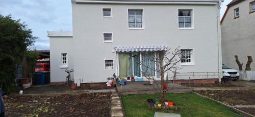ein weißes Haus mit einem Baum im Vorgarten in der Unterkunft Blumenblick in Kirchhain