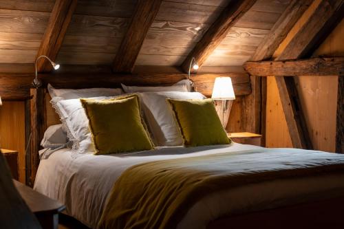 a bedroom with a large bed with green pillows at La Grange d'Hannah - gîte & chambre d’hôtes de charme in Orbey