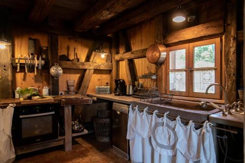 una cocina con paredes de madera y un lavabo con toallas blancas. en La Grange d'Hannah - gîte & chambre d’hôtes de charme en Orbey