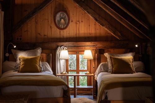 two beds in a room with wooden walls at La Grange d'Hannah - gîte & chambre d’hôtes de charme in Orbey