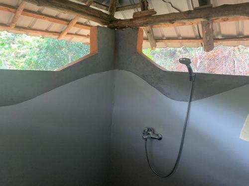 a shower in a bathroom with a window at Sahana Retreat in Buttala