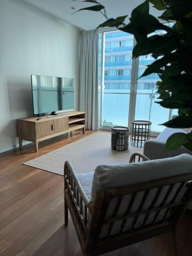 a living room with a couch and a television at Plaza Funchal - Coração da cidade in Funchal