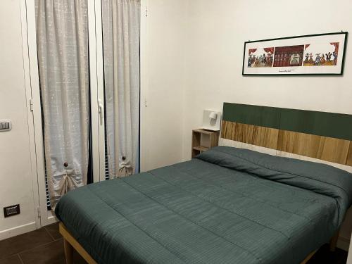 a bedroom with a bed with a green comforter at Casa SERGE vista mare con ampio terrazzo privato in Bergeggi