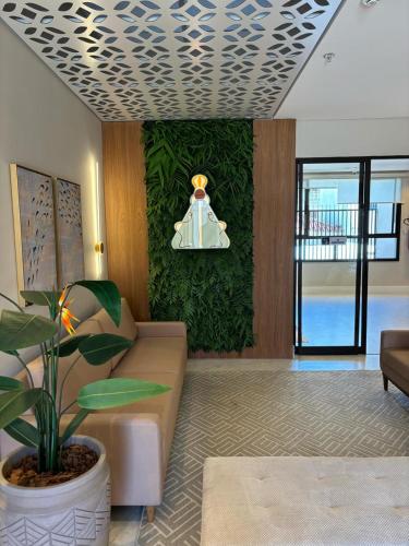 un salon avec un canapé et une plante dans l'établissement Hotel Mãe Morena, à Aparecida