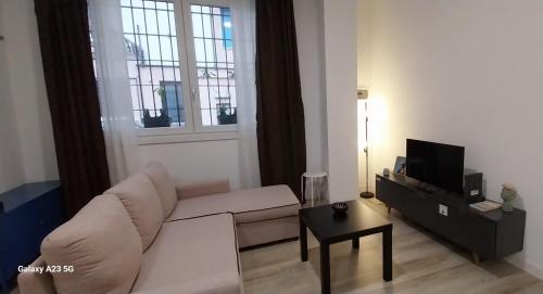 un soggiorno con divano bianco e TV di Loft Bacchiglione a Milano