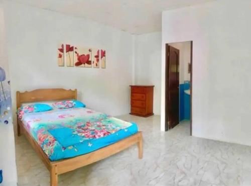a bedroom with a bed with a blue comforter at Casa París “Tropical” in Montañita