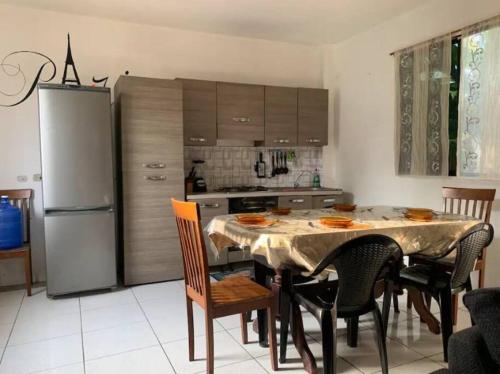 a kitchen with a table with chairs and a refrigerator at Casa París “Tropical” in Montañita