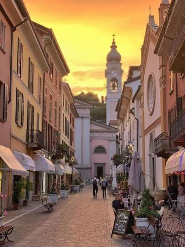 a city street with a clock tower in the distance at Mansarda in centro Menaggio con spiaggia privata e possibilità garage in Menaggio