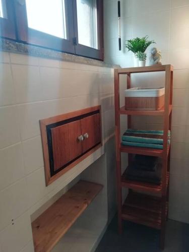 a bathroom with a sink and a wooden shelf at Mansarda in centro Menaggio con spiaggia privata e possibilità garage in Menaggio