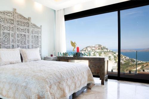 sypialnia z łóżkiem i dużym oknem w obiekcie Villa Calista by Important Group Travel w mieście Yalıkavak