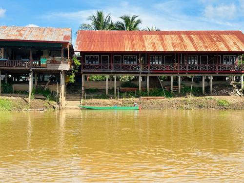 Muang Không的住宿－Happy bangalow riverside，河边的建筑物,有水