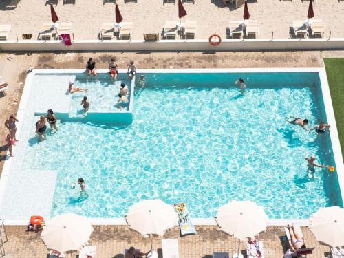 einen Blick über einen Pool mit Menschen darin in der Unterkunft Hotel Classic in Lido di Savio