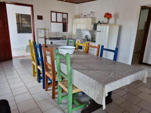 een keuken met een tafel en een aantal stoelen en een tafel en een keuken bij Praia Itapeva in Torres