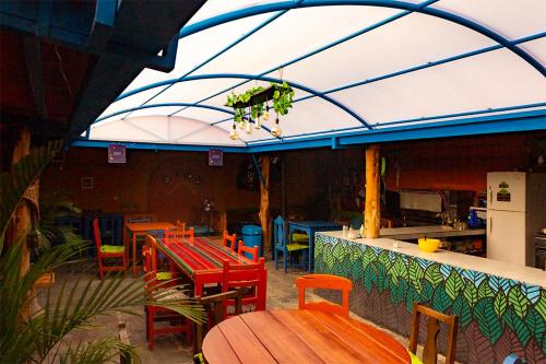 a patio with tables and chairs and a kitchen at Hostal Café Tiana in Latacunga